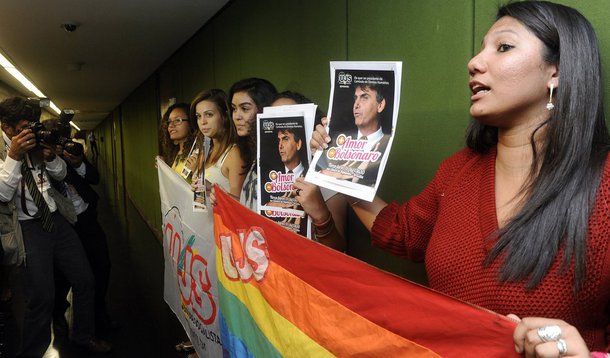 Cinco jovens protestaram nesta terça (11) contra a possibilidade de indicação do deputado Jair Bolsonaro (PP-RJ) para a presidência da Comissão de Direitos Humanos e Minorias da Câmara dos Deputados; "Não permitiremos que Jair Bolsonaro chegue à presidência da Comissão de Direitos Humanos. Queremos convocar a sociedade brasileira a rejeitar a vontade pessoal e política dele assumir a presidência, disse a diretora de Jovens Feministas da UJS, Maria das Neves, uma das participantes do ato; Bolsonaro reagiu: "Minoria tem que se calar, se curvar à maioria"
 