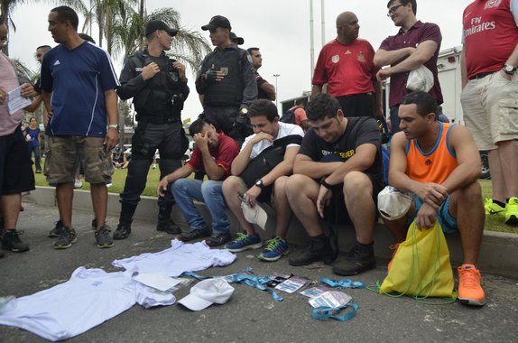 Quatro homens foram presos pela PM por envolvimento na comercialização de credenciais falsas para ter acesso à área vip de uma das empresas patrocinadoras da Copa, no Estádio do Maracanã, durante a partida entre o Chile e a Espanha; eles tentavam vender as credenciais por R$ 1,5 mil cada