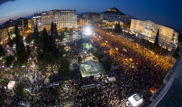 Milhares de pessoas se reúniram na Praça Syntagma, no centro de Atenas, na chuva, para manifestar apoio à permanência da Grécia na zona do euro; marcha, organizada por partidos de oposição e entidades de comércio e indústria, acontece menos de cinco dias antes do referendo que decidirá se a Grécia aceita as condições impostas pelos credores para um acordo sobre a dívida grega