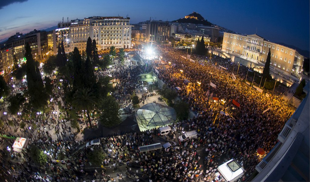 Milhares de pessoas se reúniram na Praça Syntagma, no centro de Atenas, na chuva, para manifestar apoio à permanência da Grécia na zona do euro; marcha, organizada por partidos de oposição e entidades de comércio e indústria, acontece menos de cinco dias antes do referendo que decidirá se a Grécia aceita as condições impostas pelos credores para um acordo sobre a dívida grega