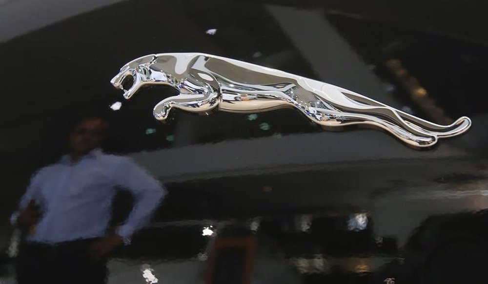 Reflexo de um homem perto do logotipo de um veículo da Jaguar, em Mumbai. A fabricante de carros de luxo britânica Jaguar Land Rover vendeu um volume recorde de veículos no ano passado, quando o aumento da demanda em mercados como Brasil, China, Índia e E