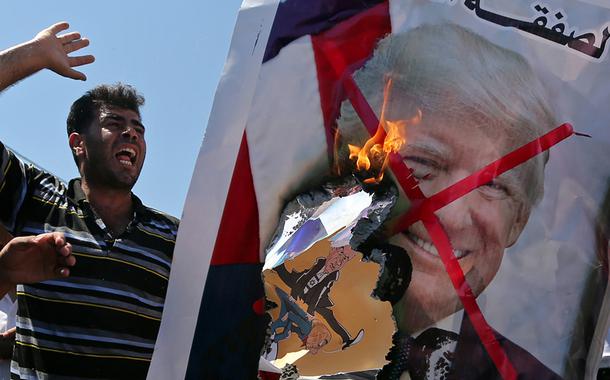 Manifestantes palestinos queimam retrato do presidente  Donald Trump