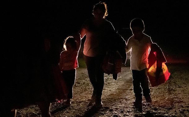 Mulher de Honduras com dois filhos é acompanhada por agente de fronteira dos EUA