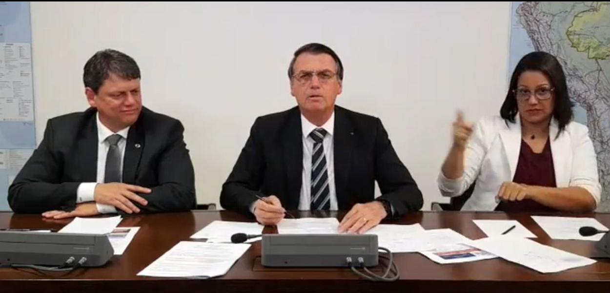 O presidente Jair Bolsonaro faz transmissÃ£o ao vivo ao lado do ministro da Infraestrutura, TarcÃ­sio Gomes de Freitas, e da intÃ©rprete de libras, ElizÃ¢ngela Castelo Branco.