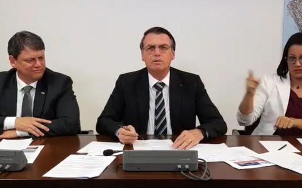 O presidente Jair Bolsonaro faz transmissÃ£o ao vivo ao lado do ministro da Infraestrutura, TarcÃ­sio Gomes de Freitas, e da intÃ©rprete de libras, ElizÃ¢ngela Castelo Branco.