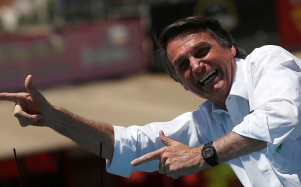 Jair Bolsonaro faz sinal de armas com as mãos