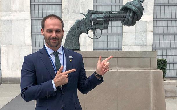 Eduardo Bolsonaro faz gesto de arma em frente a monumento pela paz