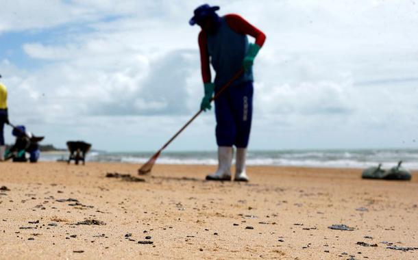 As pessoas removem um derramamento de óleo na praia de Coruripe, estado de Alagoas, Brasil, 14 de outubro de 2019. REUTERS / Adriano Machado