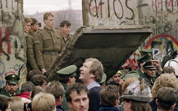 West Berliners crowd in front of the Berlin Wall early 11 November 1989 as they watch East German border guards demolishing a section of the wall in order to open a new crossing point between East and West Berlin, near the Potsdamer Square. Two days before, Gunter Schabowski, the East Berlin Communist party boss, declared that starting from midnight, East Germans would be free to leave the country, without permission, at any point along the border, including the crossing-points through the Wall in Berlin. The Berlin concrete wall was built by the East German government in August 1961 to seal off East Berlin from the part of the city occupied by the three main Western powers to prevent mass illegal immigration to the West. According to the "August 13 Association" which specialises in the history of the Berlin Wall, at least 938 people - 255 in Berlin alone - died, shot by East German border guards, attempting to flee to West Berlin or West Germany.