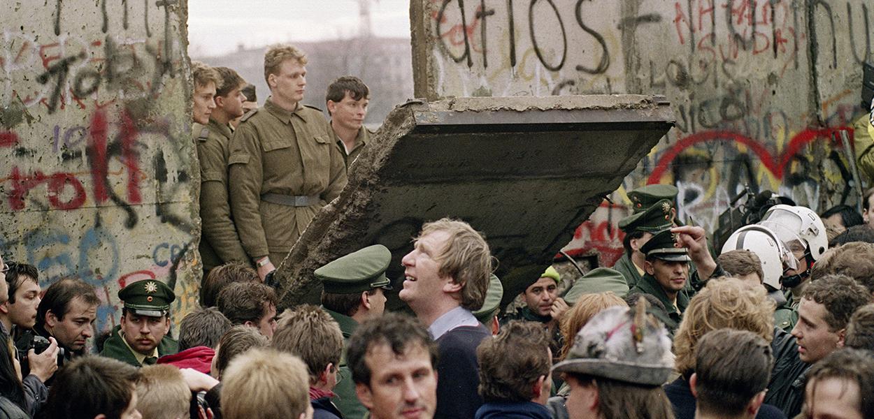 West Berliners crowd in front of the Berlin Wall early 11 November 1989 as they watch East German border guards demolishing a section of the wall in order to open a new crossing point between East and West Berlin, near the Potsdamer Square. Two days before, Gunter Schabowski, the East Berlin Communist party boss, declared that starting from midnight, East Germans would be free to leave the country, without permission, at any point along the border, including the crossing-points through the Wall in Berlin. The Berlin concrete wall was built by the East German government in August 1961 to seal off East Berlin from the part of the city occupied by the three main Western powers to prevent mass illegal immigration to the West. According to the "August 13 Association" which specialises in the history of the Berlin Wall, at least 938 people - 255 in Berlin alone - died, shot by East German border guards, attempting to flee to West Berlin or West Germany.