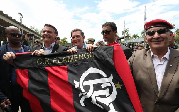 Bolsonaro caminha com a faixa do Flamengo ao lado de Marcelo Crivella