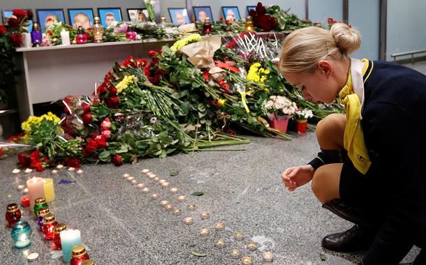 Colega de tripulantes do voo da Ukraine International Airlines que caiu pouco após decolar de Teerã coloca velas em memorial no aeroporto Boryspil, em Kiev