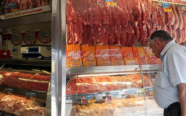 Homem compra carne em um açougue de Santo André, São Paulo.