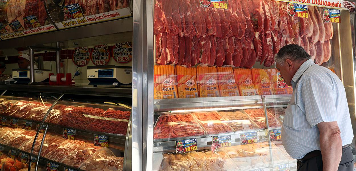 Homem compra carne em um açougue de Santo André, São Paulo.