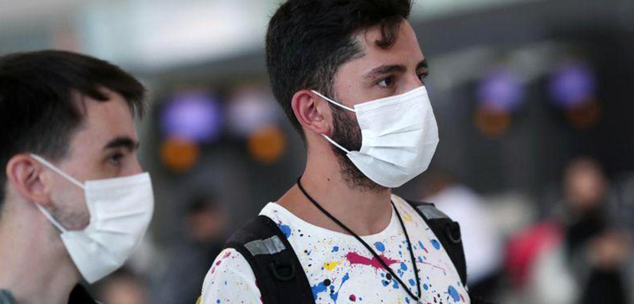 Viajantes usam máscaras no aeroporto de Guarulhos.