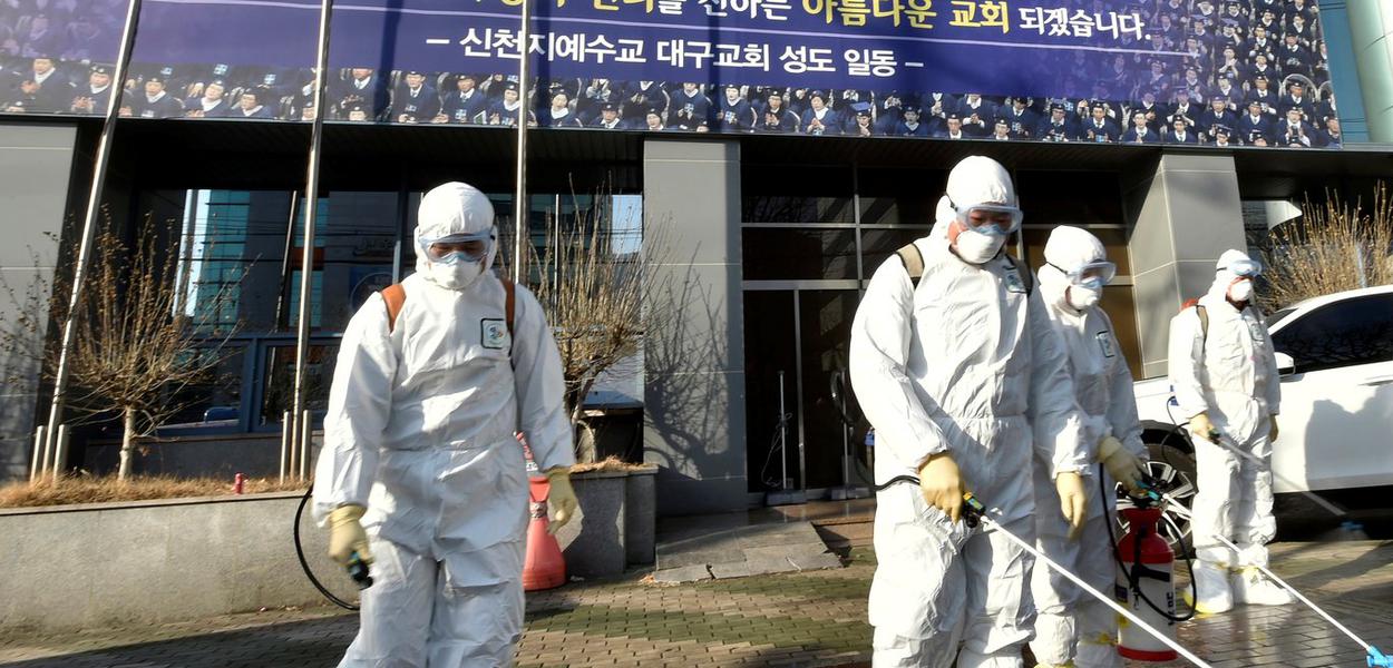 Funcionários de uma empresa de dedetização  desinfectam rua em frente à Igreja de Jesus o Templo do Tabernáculo do Testemunho, em Daegu