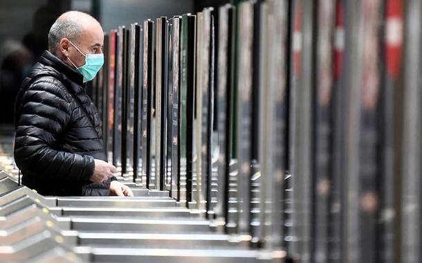 Homem de máscara em estação de metrô de Milão