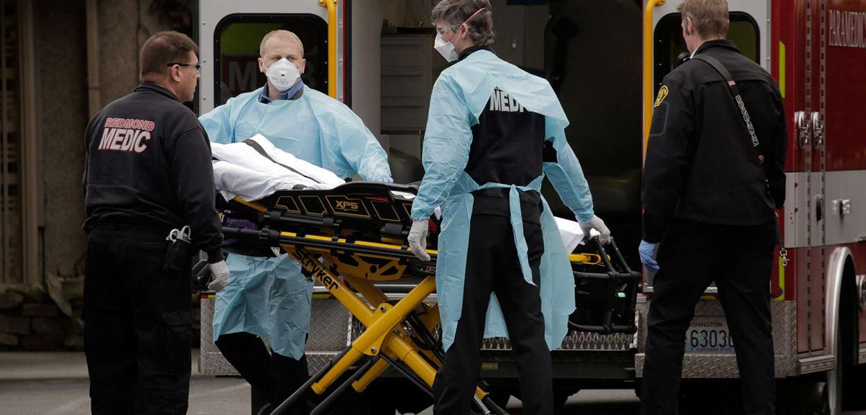 Médicos preparando paciente para ambulância