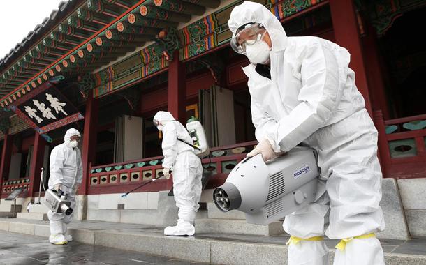 Agentes de saúde sanitizam palácio tradicional de Suwon, na Coreia do Sul, por temor de disseminação do coronavírus da China.