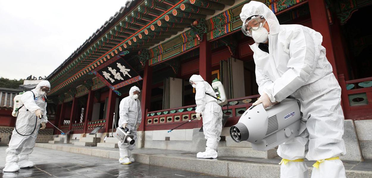 Agentes de saúde sanitizam palácio tradicional de Suwon, na Coreia do Sul, por temor de disseminação do coronavírus da China.