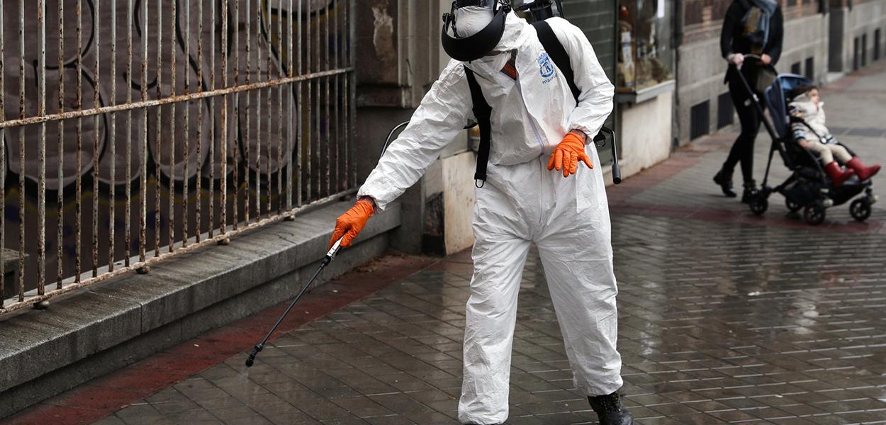 Homem desinfeta rua em Madri, Espanha