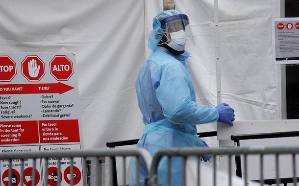 Agente de saúde com traje de proteção entra em hospital em Nova York