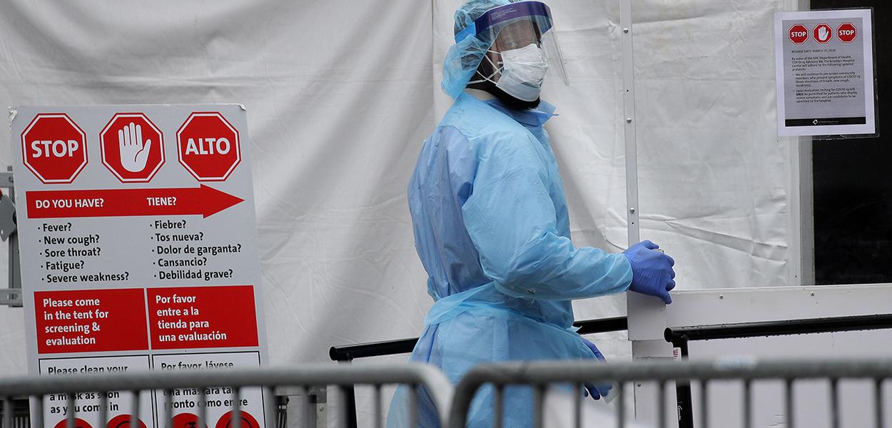 Agente de saúde com traje de proteção entra em hospital em Nova York