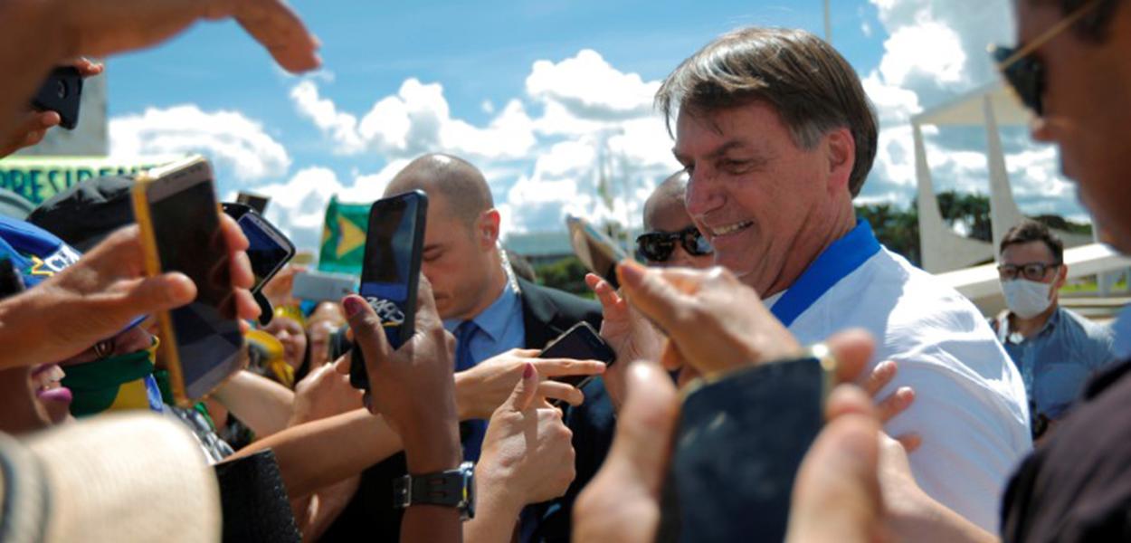 Jair Bolsonaro cumprimenta apoiadores em frente ao Palácio do Planalto durante manifestação, já em meio à epidemia do coronavírus