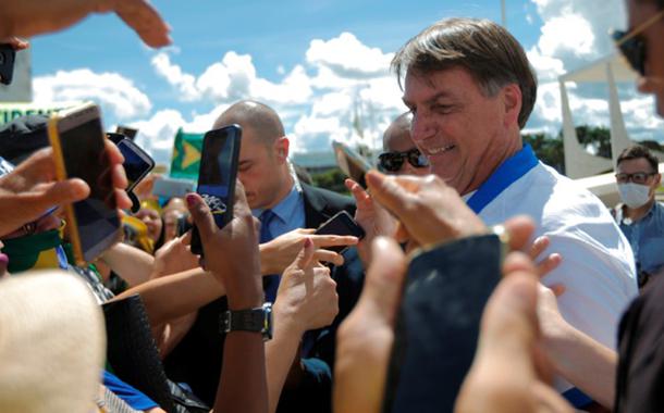 Jair Bolsonaro cumprimenta apoiadores em frente ao Palácio do Planalto durante manifestação, já em meio à epidemia do coronavírus