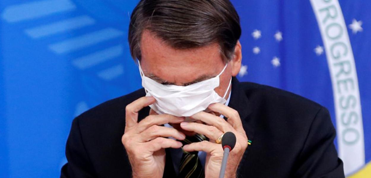 Jair Bolsonaro coloca máscara durante entrevista coletiva sobre coronavírus no Palácio do Planalto