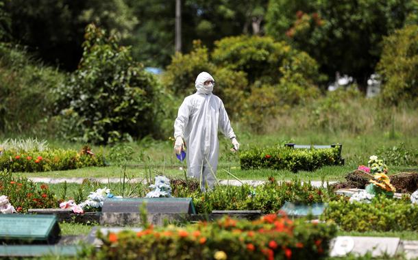 Um coveiro é visto durante o enterro de Ester Melo da Silva, 67 anos, que morreu em razão da doença por coronavírus (COVID-19), no cemitério Parque Tarumã em Manaus, AM, Brasil.