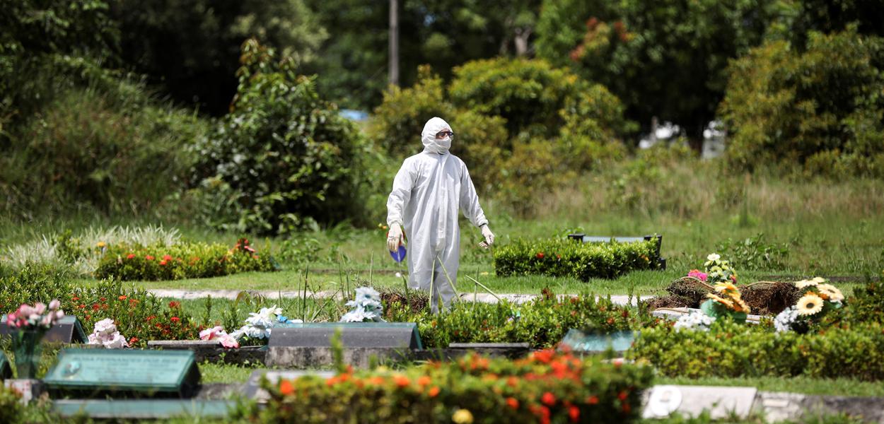 Um coveiro é visto durante o enterro de Ester Melo da Silva, 67 anos, que morreu em razão da doença por coronavírus (COVID-19), no cemitério Parque Tarumã em Manaus, AM, Brasil.