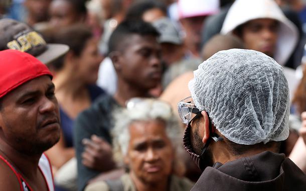 Fila para receber alimentos doados por padres franciscanos no centro de São Paulo durante a crise do coronavírus