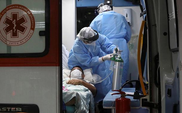Agentes de saúde transferem paciente do novo coronavírus em ambulância