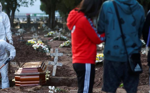 Famílias acompanham enterros de vítimas do coronavírus no Rio de Janeiro.