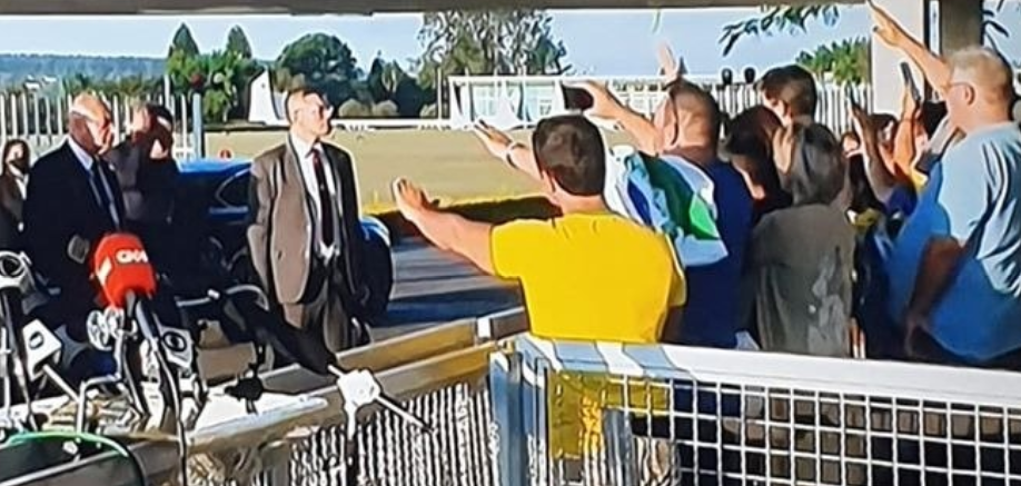 Apoiadores fazem gesto em direção a Bolsonaro em frente ao Palácio da Alvorada