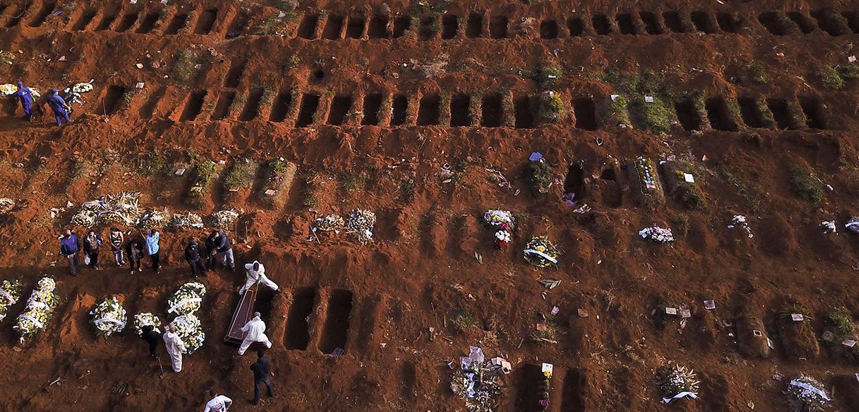 Sepultadores com trajes de proteção enterram vítima de Covid-19 no cemitério de Vila Formosa, em São Paulo 22/05/2020