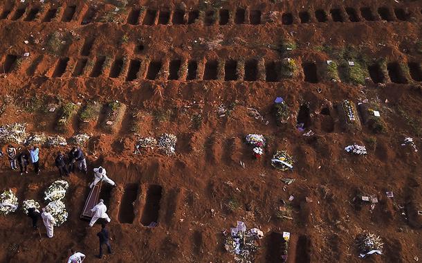 Sepultadores com trajes de proteção enterram vítima de Covid-19 no cemitério de Vila Formosa, em São Paulo 22/05/2020