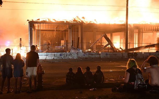 Protesters gather near the Minneapolis Police third precinct to watch a construction site burn after a white police officer was caught on a bystander's video pressing his knee into the neck of African-American man George Floyd, who later died at a hospital, in Minneapolis, Minnesota, U.S. May 28, 2020.