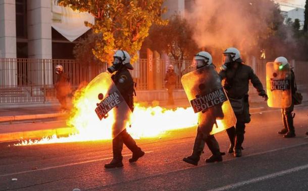 A polícia de choque passou por chamas enquanto reprimia manifestantes durante uma manifestação contra a morte na custódia policial de George Floyd, em Minneapolis, fora da embaixada dos EUA em Atenas, Grécia (3.6.20)