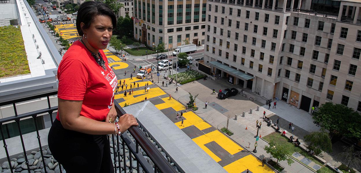 Prefeita de Washington, Muriel Bowser, observa frase "Black Lives Matter" pintada em enormes letras amarelas