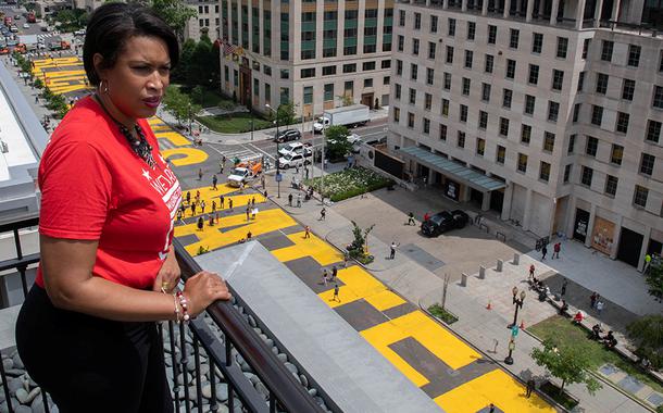 Prefeita de Washington, Muriel Bowser, observa frase "Black Lives Matter" pintada em enormes letras amarelas