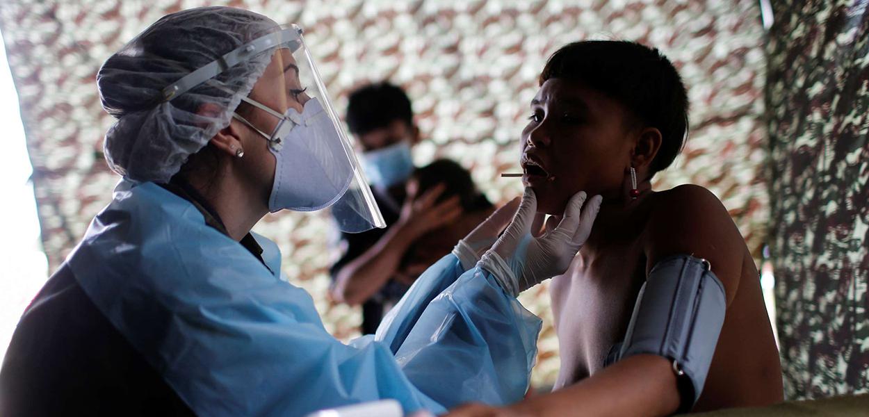 Integrante das Forças Armadas examina índio ianomâmi em Alto Alegre, Roraima