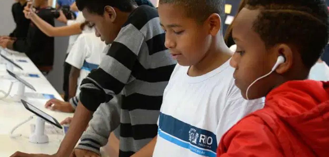 Crianças usam eletrônicos no Rio: coronavírus deve forçar gigantesca experiência de aulas remotas no Brasil