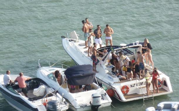 Jovens violam quarentena e tiram máscaras em lancha