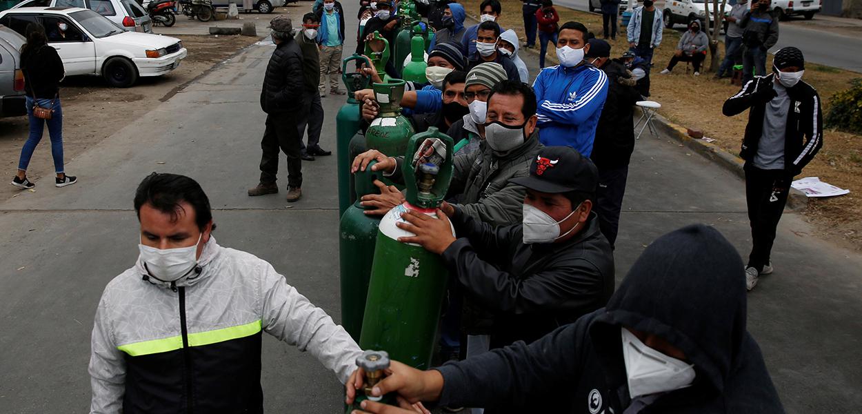 Pessoas fazem fila para recarregar cilindros de oxigênio em Lima, no Peru