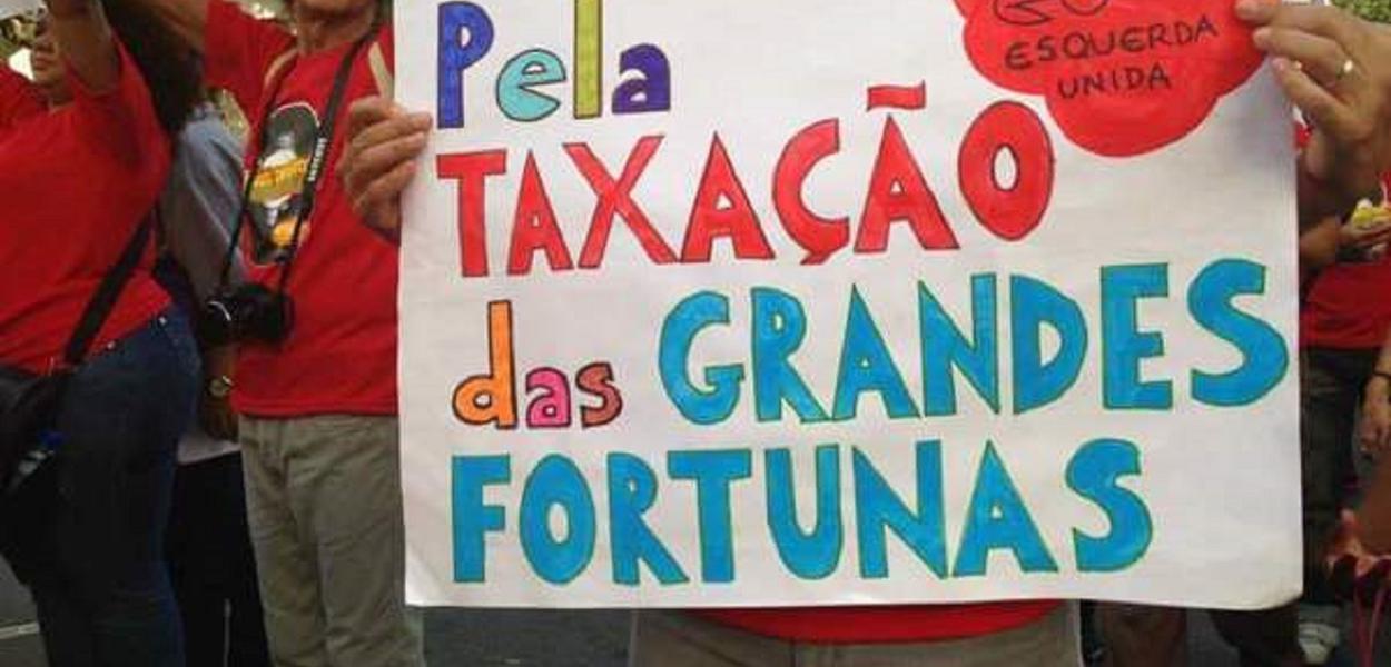 Manifestante protesta pela taxação de grandes fortunas