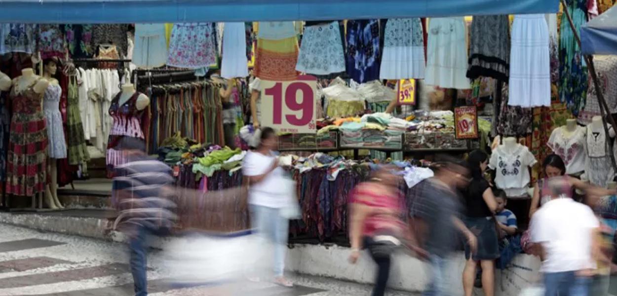 Pessoas passam em frente a loja em rua comercial de São Paulo