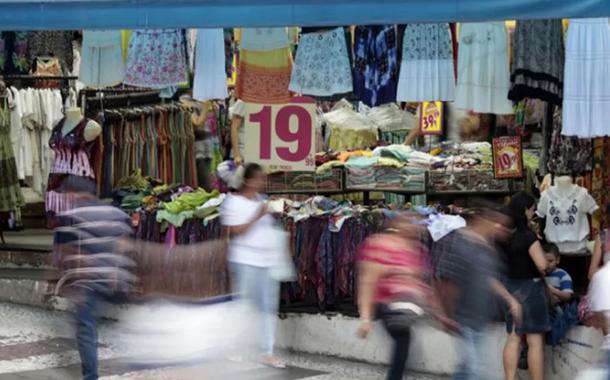 Pessoas passam em frente a loja em rua comercial de São Paulo