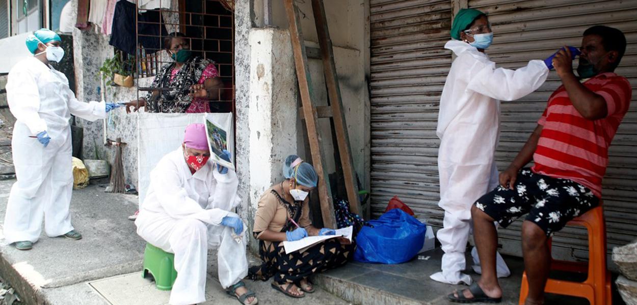 Profissionais da saúde recolhem material para testes de Covid-19 nas ruas de Mumbai, na Índia